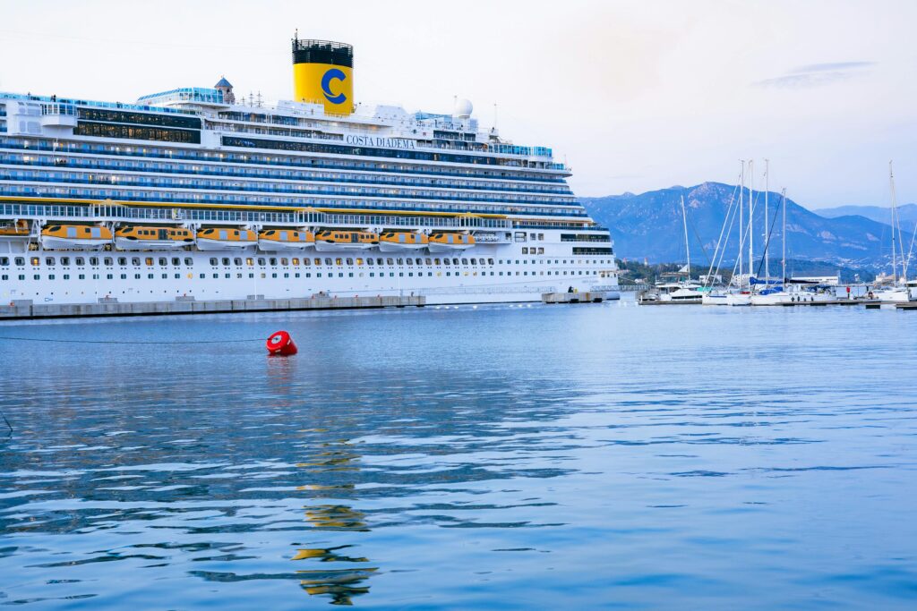 Stunning view of a cruise ship docked at Ajaccio port, Corsica with scenic mountain backdrop.