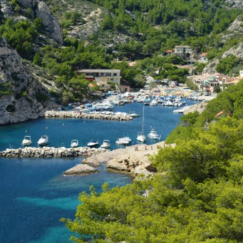 Picturesque calanque in Marseille with clear blue water and lush greenery.